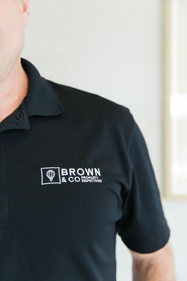 Brown & Co Property Inspections logo on inspector uniform shirt.