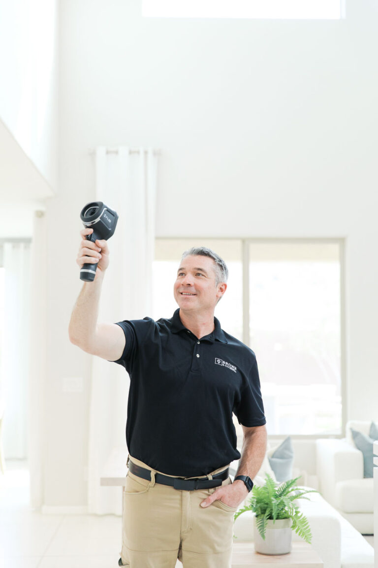 Home inspector using thermal imaging camera in a residential building.