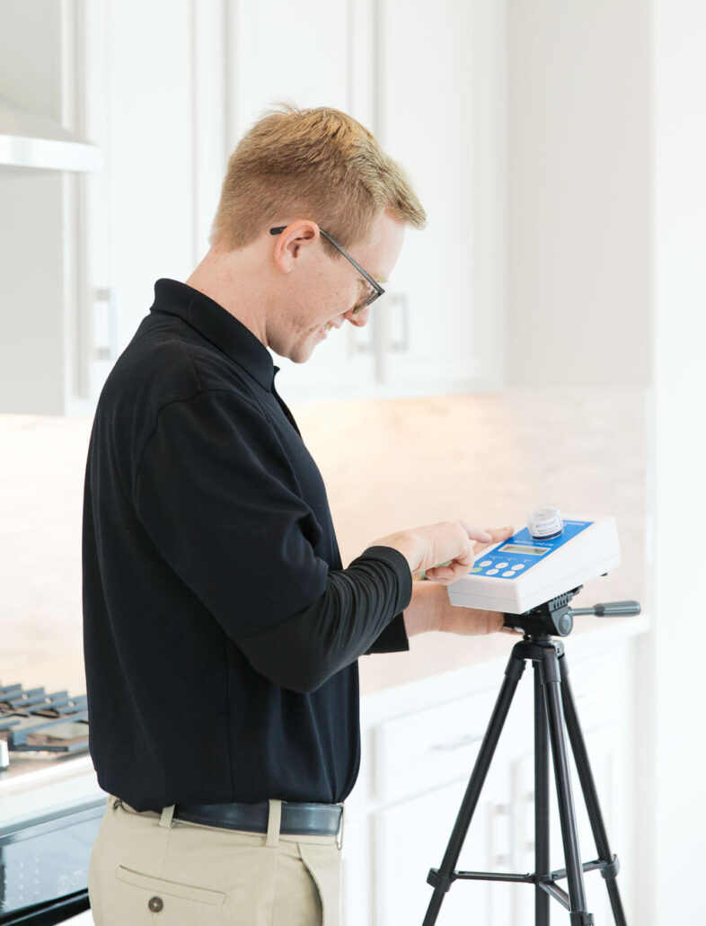 Inspector operating indoor air quality testing device for mold and environmental assessment.